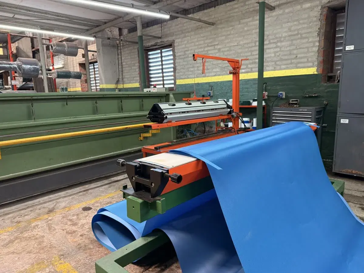 Máquina cortadora procesando banda PVC azul grado alimenticio